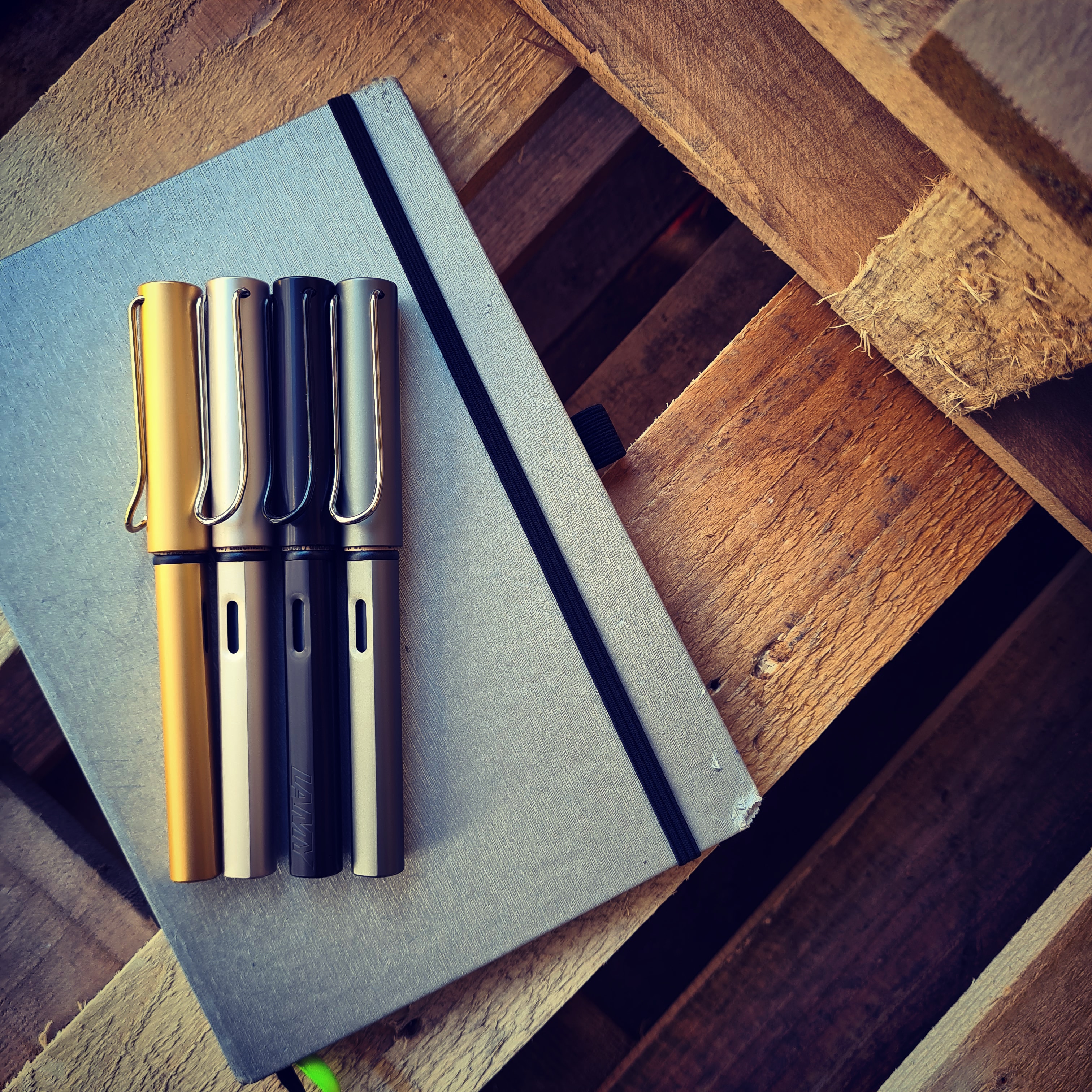 Vier Füller liegen auf einem Notizbuch